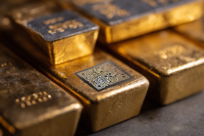 Physical gold bars stacked neatly with a BTC hologram chip embedded on one