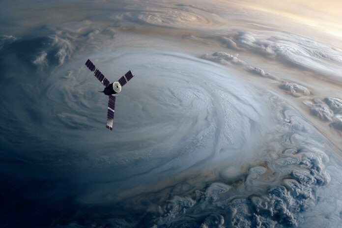 Juno spacecraft orbiting above Jupiter's swirling atmosphere, with diffuse layers blending toward the center.