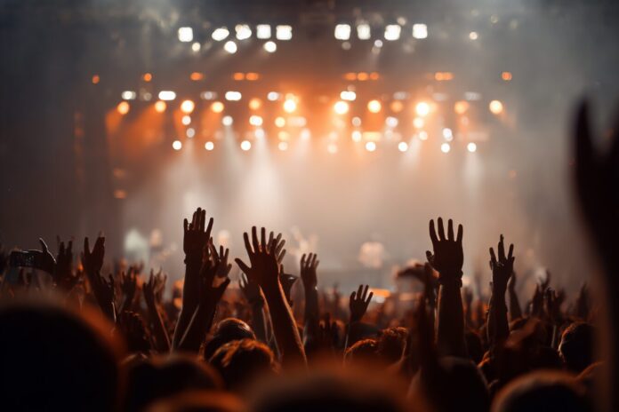 Concert crowd with raised hands under stage lights, symbolizing live events demand for StubHub IPO coverage