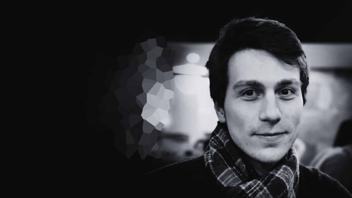 Igor Babuschkin, co-founder of xAI, standing in front of the company's logo at a conference.
