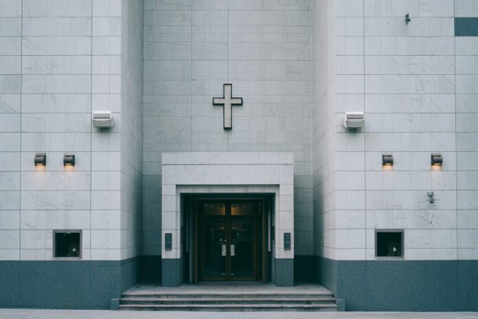 Modern church facade with security cameras visible above the entrance.