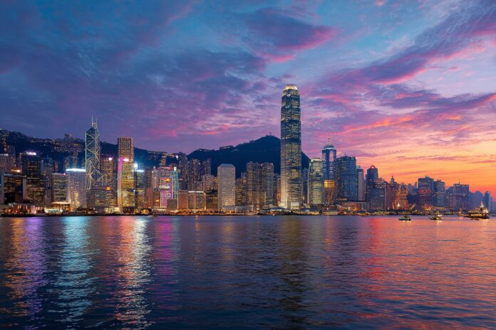 Hong Kong skyline with iconic Victoria Harbour and city lights at dusk, illustrating the city's financial vibrancy.