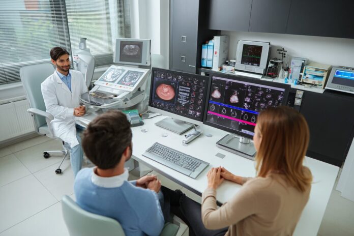 A modern fertility clinic lab with advanced digital embryo monitoring equipment and a diverse couple consulting with a fertility specialist.