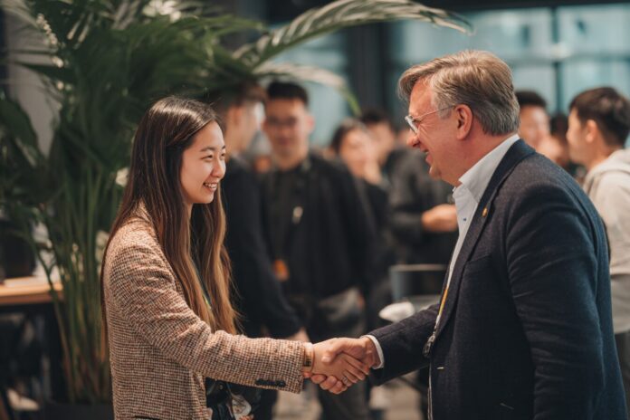 China Renaissance and YZi Labs representatives shaking hands at a Web3 investment signing event.