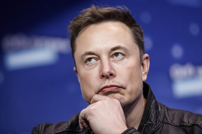 Elon Musk speaking at a tech conference, looking intense and thoughtful.