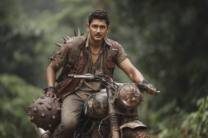 Mahesh Babu in rugged jungle attire, holding a spiked ball weapon and sitting on a motorbike.