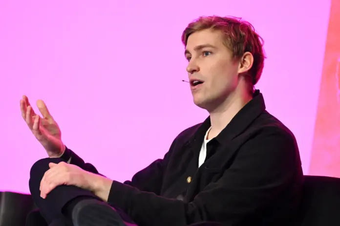 Mati Staniszewski speaking on stage at TechCrunch Disrupt 2025 during a presentation on future voice AI.
