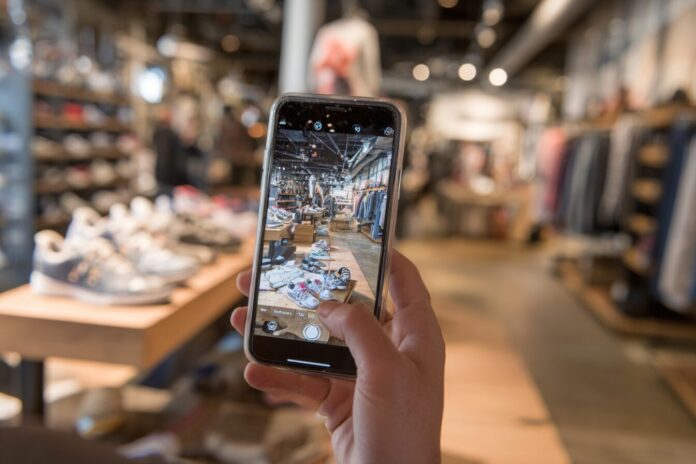 Person using Amazon Lens Live on their smartphone to scan shoes in a real-world store.
