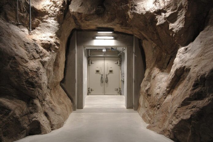 A reinforced underground bunker entrance with secured doors, converted into a modern data center.