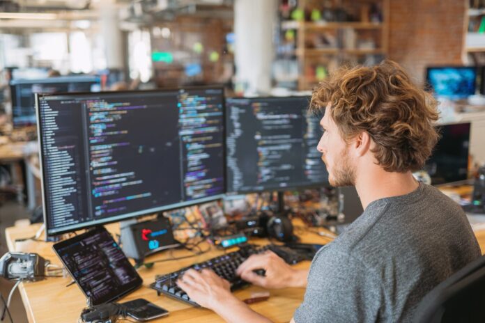 A developer collaborates with AI tools on code in a modern workspace