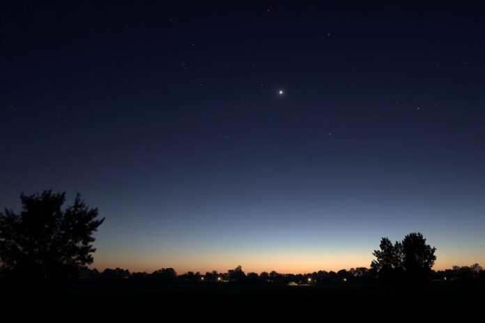 A clear predawn sky with Mercury and Regulus near the horizon, Venus higher up, faint twilight glow.