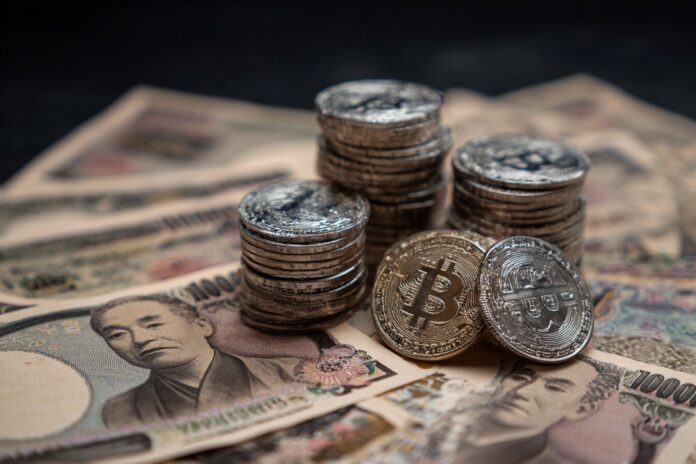 Japanese yen bills and digital cryptocurrency coins stacked together