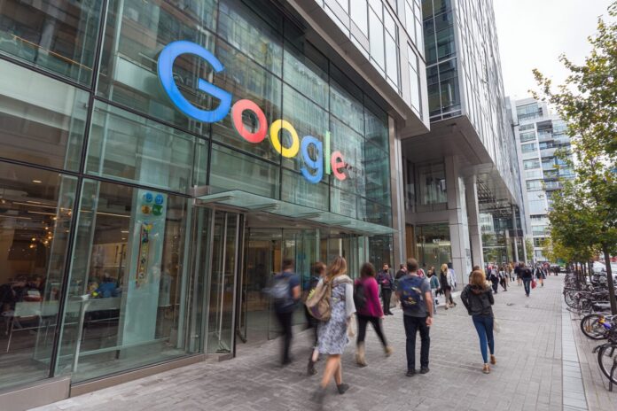 A Google office exterior with people walking by, reflecting a busy tech workplace