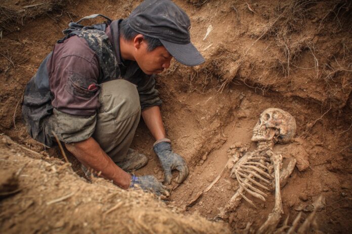 Excavation of a crouched skeleton at a Southeast Asian archaeological site.