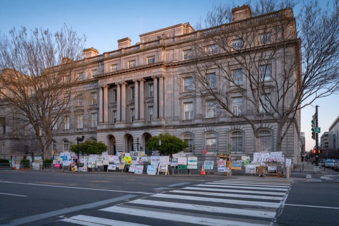 EPA headquarters building with protest signs outside.