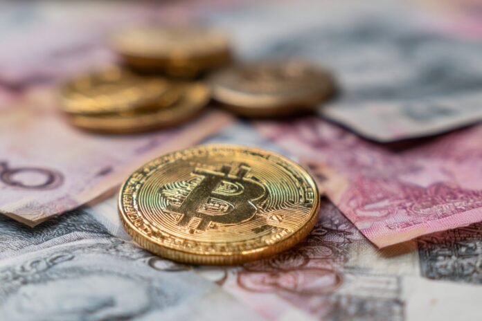 A golden Bitcoin standing out against a backdrop of declining fiat currency notes.