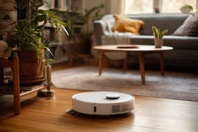 A robot vacuum with an extended brush cleaning in a living room corner.