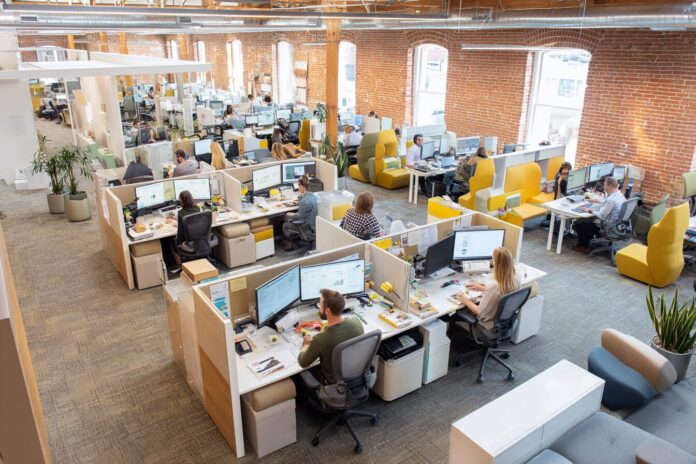 A diverse, engaged team collaborating in a bright, flexible open office with relaxed work zones.
