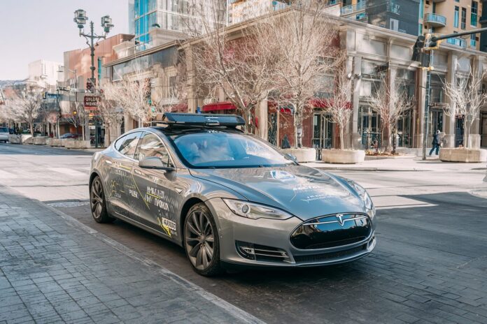 Autonomous Tesla vehicle with Nevada test plates in urban setting