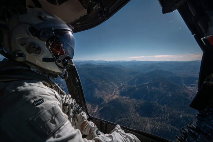 NASA astronaut pilots helicopter over Colorado mountains during Artemis training exercise.