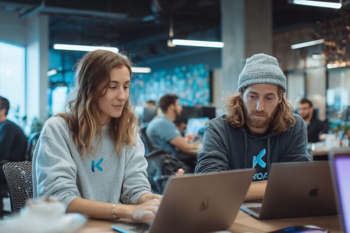 Founders of Koah collaborating on their AI advertising platform in a modern office.