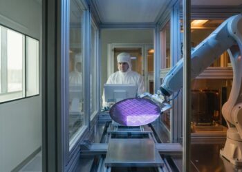 Advanced semiconductor manufacturing facility with precision equipment processing silicon wafers under controlled lighting conditions for AI chip production